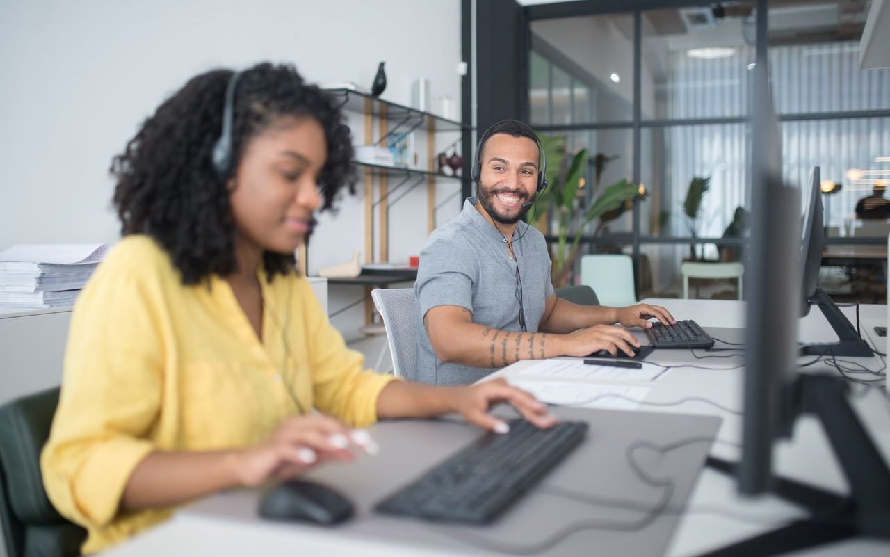 Two Tawasul agents working side by side at the contact center